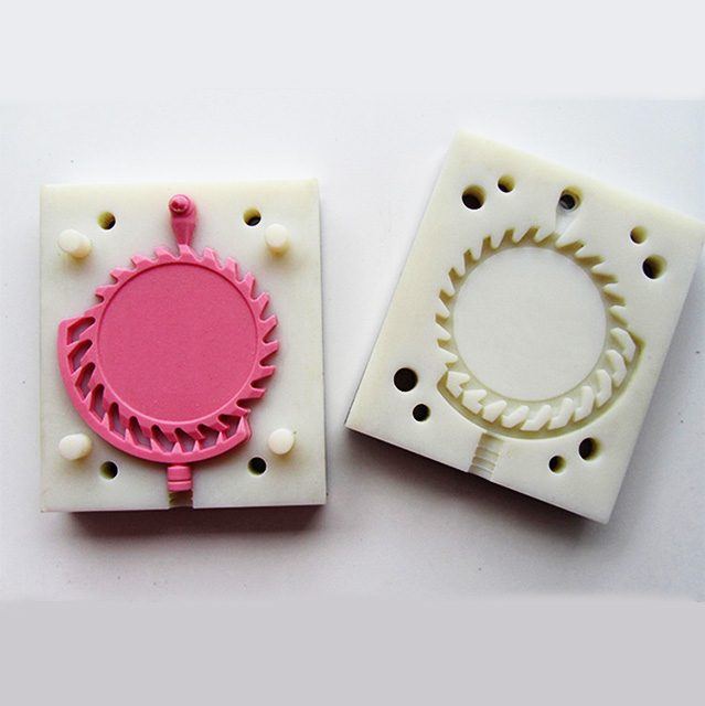 Pink master pattern inside an opened silicone mould used for vacuum casting
