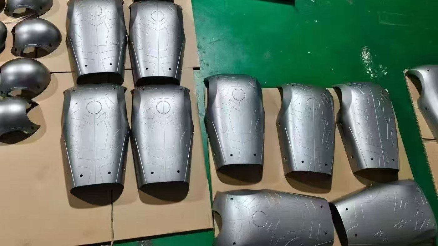 Silver robot leg shells with machined cosmetic lines staged for inspection