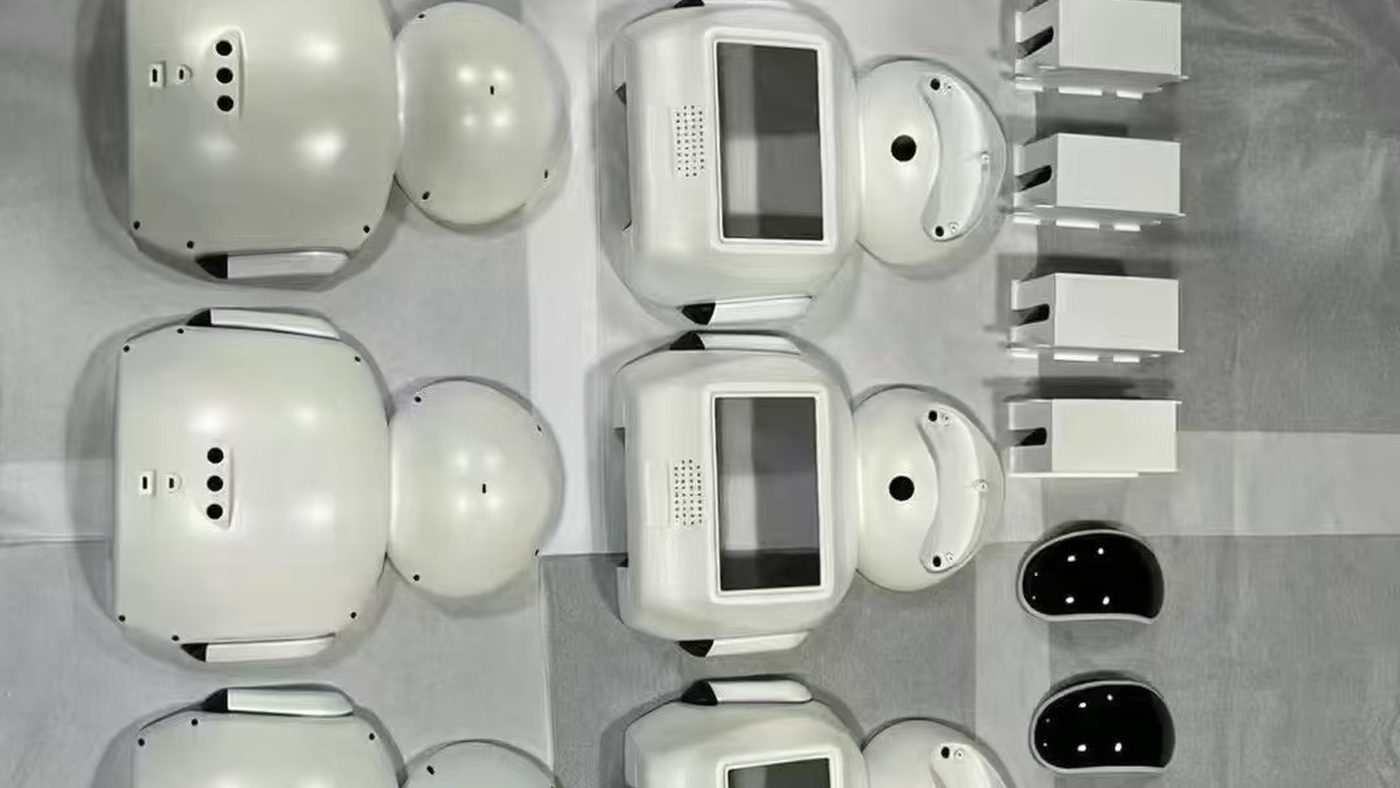 White robot enclosure shells and black faceplates laid out before assembly